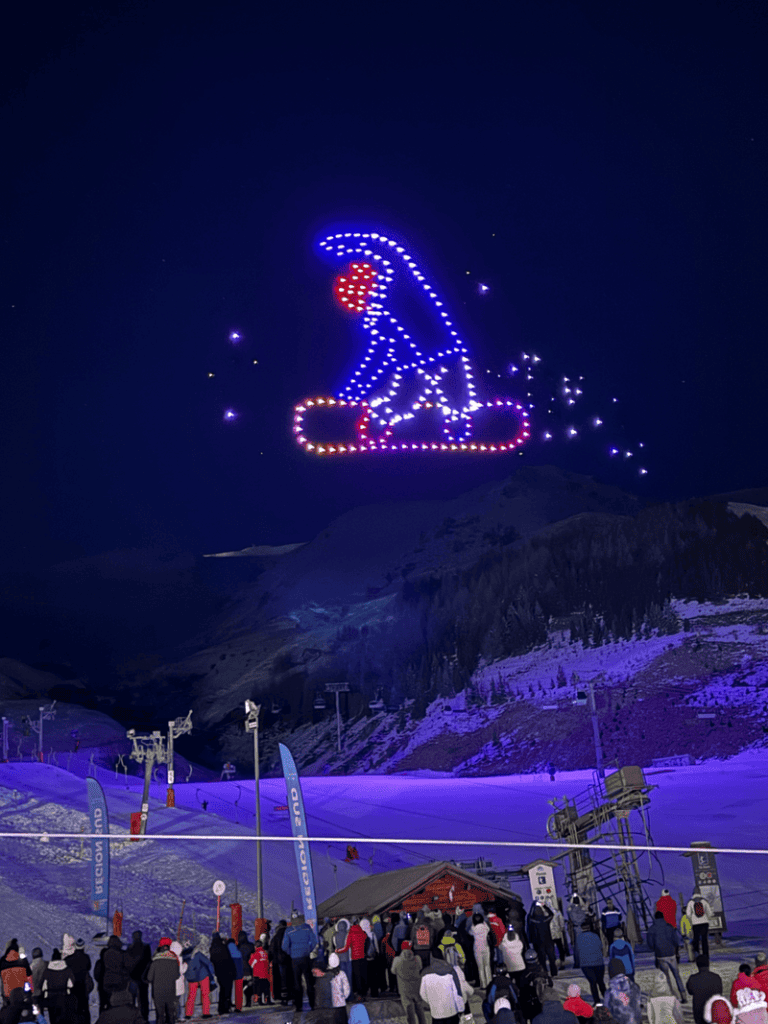 Snowboarder, der bei der Show in Les Arcs 1800 von Drohnen begleitet wurde